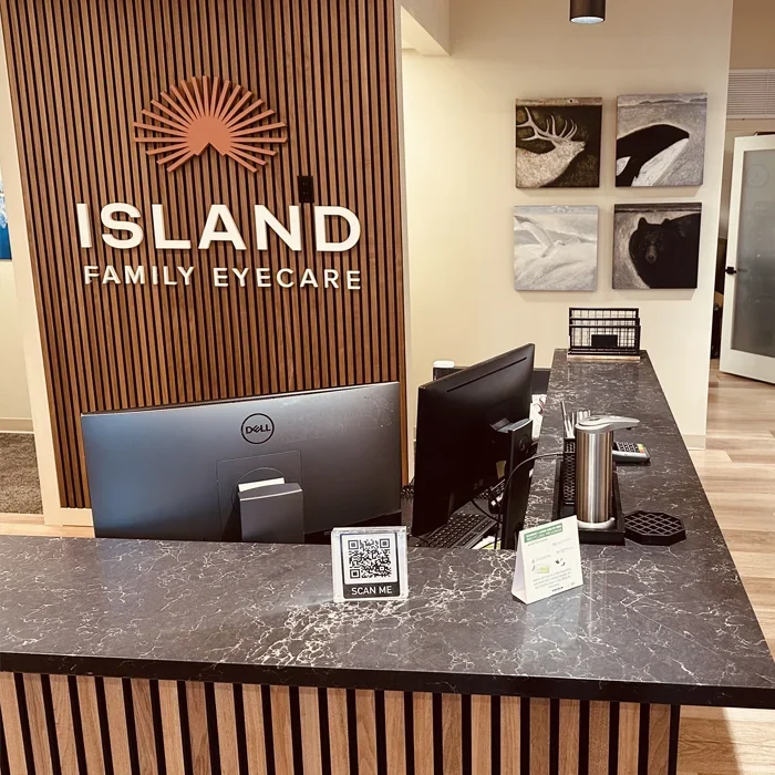 Eye Doctor Bainbridge Island WA Front Desk Front counter of Island Family Eyecare. There are computers on the counter. The clinic logo is on the wall.